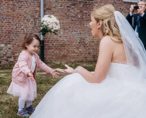 eine Braut im Spiel mit einem kleinem Mädchen