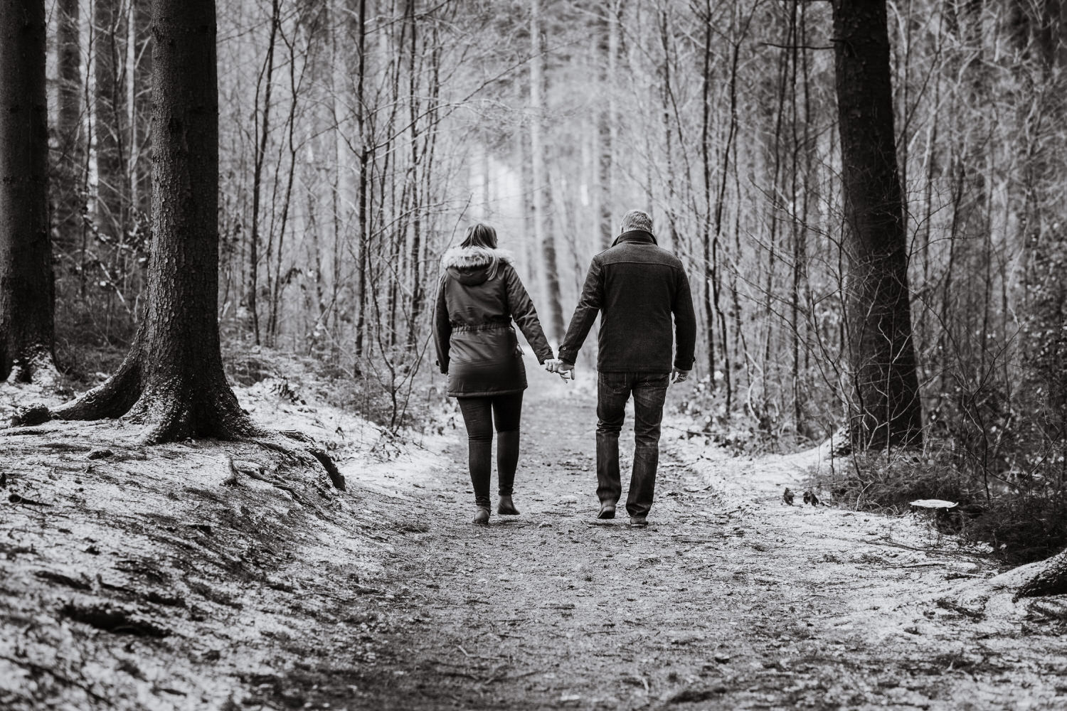 Paar beim Spaziergang durch den Wald im Winter