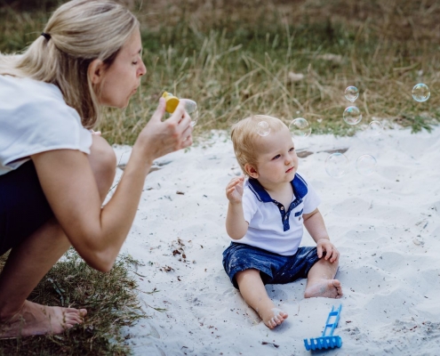 Kind und Mutter spielen mit Seifenblasen