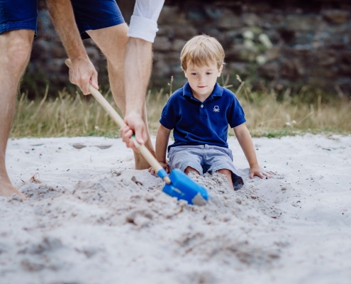 Spiele im Sandkasten mit Vater und Sohn
