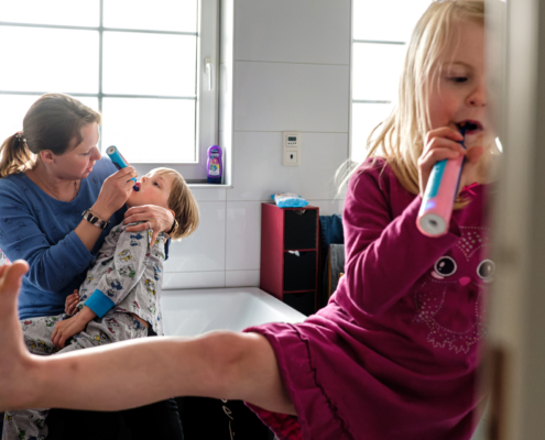 Kinder mit Mutter beim Zähneputzen