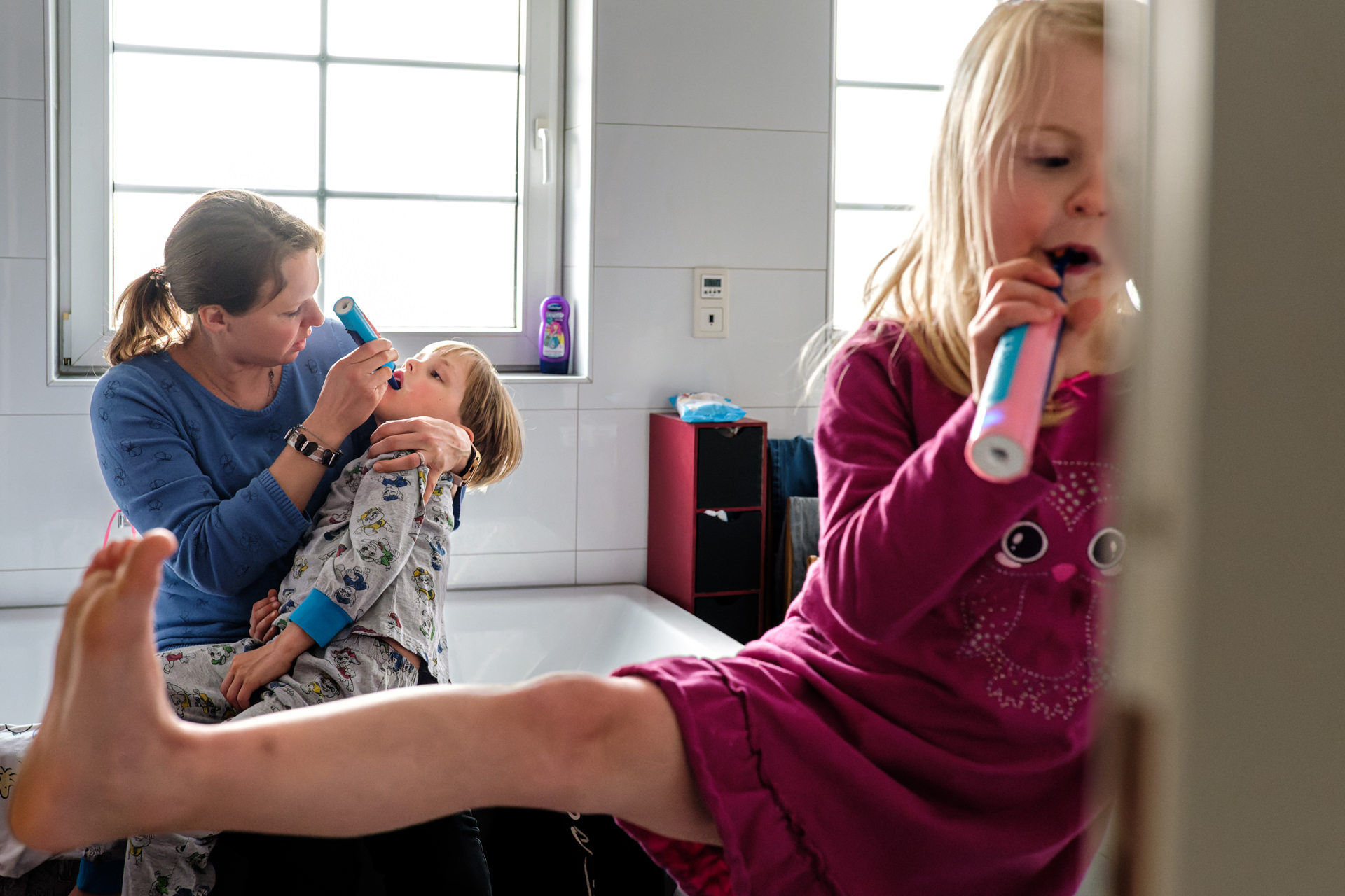 Kinder mit Mutter beim Zähneputzen